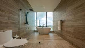 a bathroom with a tub and a toilet and a window at Mauad Hotel Boutique in Santo Domingo +37 photos