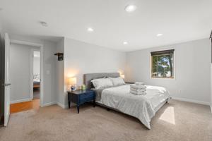 a white bedroom with a bed and a window at Cozy Pet-Friendly Condo l Pool l Dock l Walk to Parks in Oxbow