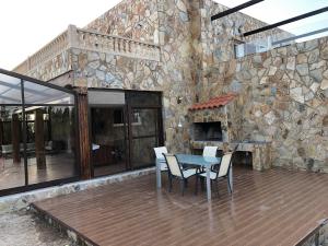 een patio met een tafel en stoelen en een stenen muur bij Coparelia in Villarrobledo