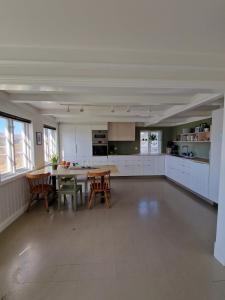 a large white kitchen with a table and chairs at Charming house by the sea in Svenevik +24 photos