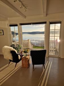 a living room with a chair and a large window at Charming house by the sea in Svenevik