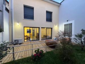 a house with a deck with a television on it at T2 modern - 10 min from Paris in Colombes