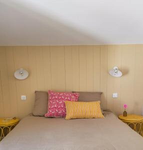 a bed in a room with two pillows on it at Feet in the water, 100 m from the city center in La Tranche-sur-Mer
