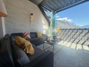 a living room with a couch and a balcony at Prestige Hyper Centre Veranda Climatisation in Saint-Jean-de-Maurienne