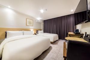 En eller flere senger på et rom på Pyeongtaek Stay Tourist Hotel