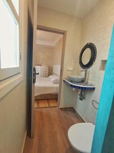 y baño con cama, espejo y lavabo. en White House, en Mirleft 60 fotos más