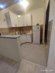 a kitchen with white cabinets and a refrigerator at Holiday Home in Trebinje +11 photos