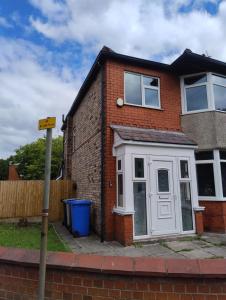 una casa de ladrillo rojo con puerta blanca en Mancunian Pride Villa, en Mánchester