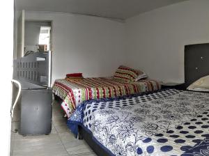 a bedroom with two beds and a television in it at My second house in Manizales