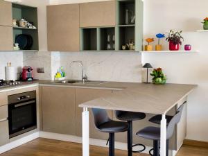 a kitchen with a table and two bar stools at BLOOM al Mare in Ventimiglia +9 photos