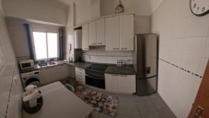 a kitchen with white cabinets and a stainless steel refrigerator at Ina's Garden in Santa Cruz in Santa Cruz +19 photos
