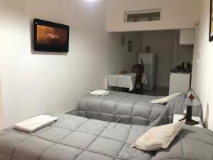 a room with two beds and a tv on the wall at Moreno924 in Barraquero