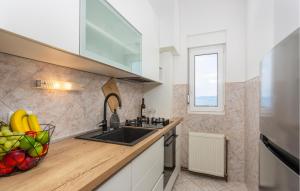a kitchen with a sink and a bowl of fruit on the counter at Awesome Apartment In Omisalj With Wifi in Omišalj