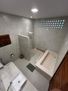 a bathroom with a shower and a sink and a tub at Casa Ventus - Arpoeiras Beach - Pé na Areia in Acaraú +50 photos