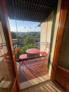 einen Balkon mit einem rosa Tisch und Stühlen darauf in der Unterkunft Casa Rosa in Montelupo Fiorentino