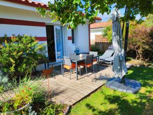 a patio with a table and chairs and an umbrella at Studio du Lac in Moliets-et-Maa