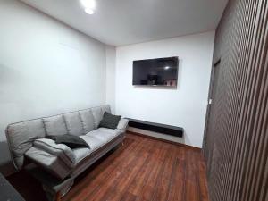 a living room with a couch and a tv on the wall at Cantinho do Ze Padeiro in Tabuaço