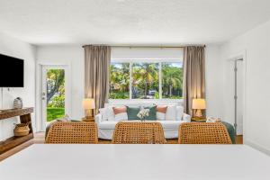 ein Wohnzimmer mit Couch und großem Fenster in der Unterkunft The Coral Cabana Modern Palm Beach Escape in West Palm Beach