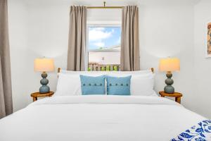 ein Schlafzimmer mit einem weißen Bett mit zwei Lampen in der Unterkunft The Coral Cabana Modern Palm Beach Escape in West Palm Beach + 43 Fotos