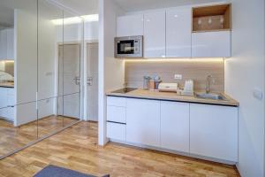 a kitchen with white cabinets and a sink at Jacuzzi Spa King Apartments FREE PARKING in Belgrade +6 photos