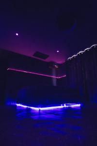 a dark room with purple and blue lights at Lov'appart in Les Anses-dʼArlets +4 photos