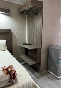 a bedroom with a bed and a wooden cabinet at Private 4 Double Room Guest Wing, Comfortable, Secure Parking, Wi-Fi, Ensuite Bath in Ermelo