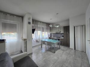 a living room with a table and a kitchen at Civico138 in Verona