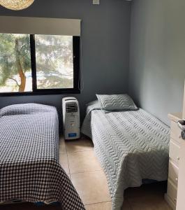 ein Schlafzimmer mit zwei Einzelbetten und einem Fenster in der Unterkunft Casa de campo, paz, tranquilidad in Concordia