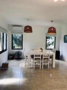 a dining room with a white table and chairs at Casa de campo, paz, tranquilidad in Concordia