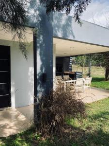 ein weißes Haus mit einem Tisch und Stühlen auf einer Terrasse in der Unterkunft Casa de campo, paz, tranquilidad in Concordia