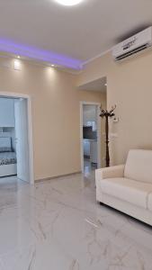 a living room with a white couch and a cross on the wall at emguesthouse in Camogli +13 photos