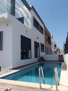 a swimming pool in front of a house at Villa Chez Badre with Pool High Standing in Sidi Rahal