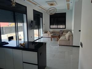 a kitchen and living room with a couch and a table at Villa Chez Badre with Pool High Standing in Sidi Rahal