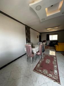 comedor con mesa, sillas y alfombra en Nader home, en Giza