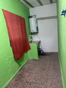 a room with a green and white wall and a television at junior alquileres in San Clemente del Tuyú