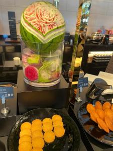 a large watermelon in a container next to a plate of oranges at サンムーン鶴間 in Yamato