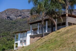 una casa in cima a una collina con palme di Fazenda Santa Ana do Garimpo a Barão de Cocais