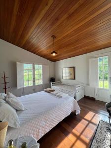 una camera da letto con un letto grande con soffitto in legno di Fazenda Santa Ana do Garimpo a Barão de Cocais Altre 96 foto