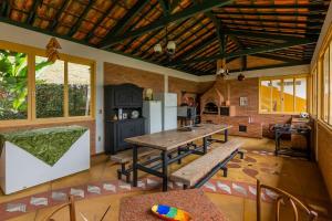 una cucina con tavolo e panche in una stanza di Fazenda Santa Ana do Garimpo a Barão de Cocais
