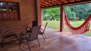 a patio with chairs and a hammock on a house at Sítio Andrez in Santa Leopoldina