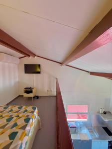a room with a bed and a desk and a television at Studio La Case Bourbon in Sainte-Anne