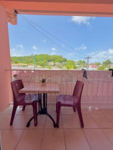 a table and two chairs on a balcony at Studio La Case Bourbon in Sainte-Anne