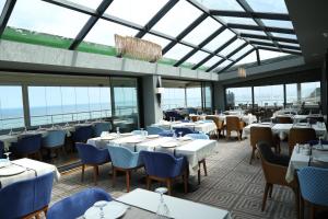 a restaurant with tables and chairs and windows at Panaroma Damla Otel in Samsun