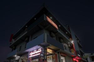 大诺伊达Super Townhouse Diamond View的一座晚上有 ⁇ 虹灯标志的建筑
