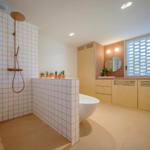 a bathroom with a tub and a toilet and a sink at Maison d'architecte sur Seine in Issy-les-Moulineaux