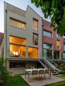a house with a table and chairs in front of it at Maison d'architecte sur Seine in Issy-les-Moulineaux