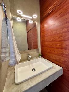 a bathroom with a white sink and a mirror at Estudio Yol-Uh Bacalar in Bacalar
