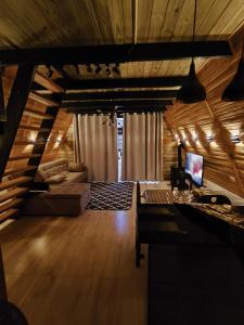 a living room with a couch and a tv at Chalé Bela Vista in Munhoz +69 photos