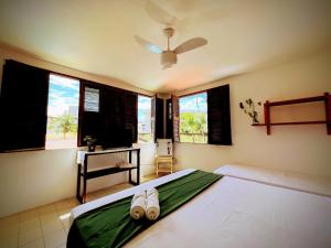 a bedroom with a bed with two pairs of shoes on it at Casa Mandacaru Cumbuco in Cumbuco