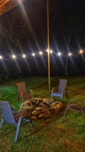 a group of chairs around a fire pit at night at Sítio Andrez in Santa Leopoldina